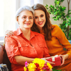 elderly woman and female caregiver smile